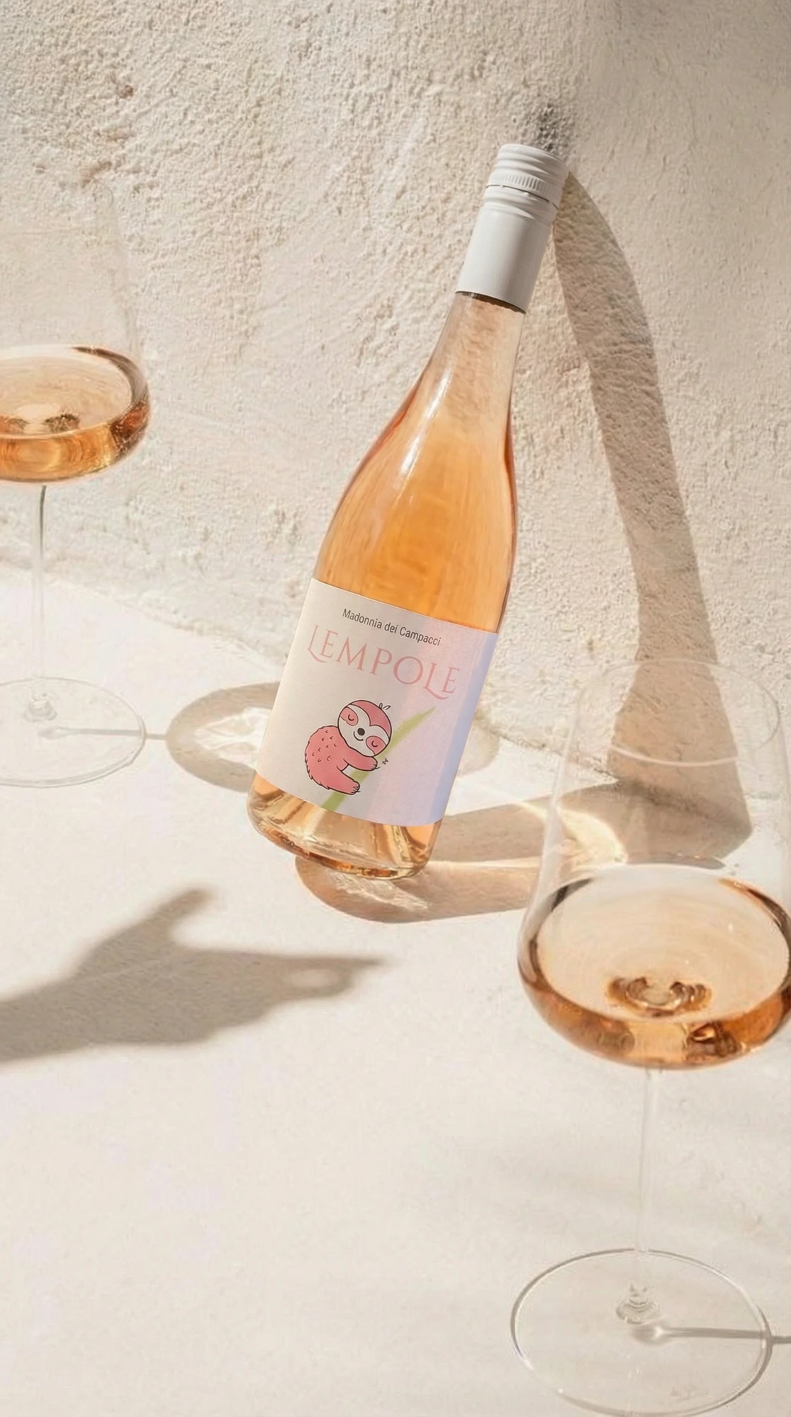 Bottiglia Lempole Rosato inclinata con calici e ombre lunghe